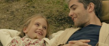 Movie still from “One Day” (2011), directed by Lone Scherfig – A man and a little girl laying in the grass; Close Up shot, High angle