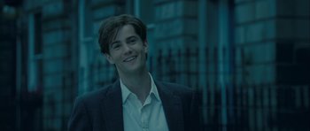Movie still from “One Day” (2011), directed by Lone Scherfig – A man in a suit smiling for the camera; Close Up shot, Over the shoulder angle