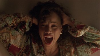 Movie still from “One False Move” (1991), directed by Carl Franklin – A woman is laying on the ground with her hands on her head; Close Up shot, Overhead angle