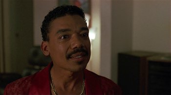 Movie still from “One False Move” (1991), directed by Carl Franklin – A person wearing a red shirt; Close Up shot, Low angle