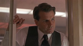 Movie still from “One False Move” (1991), directed by Carl Franklin – A person wearing a suit and tie; Close Up shot, Low angle