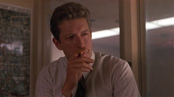 Movie still from “One False Move” (1991), directed by Carl Franklin – A person wearing a suit and tie; Close Up shot, Low angle