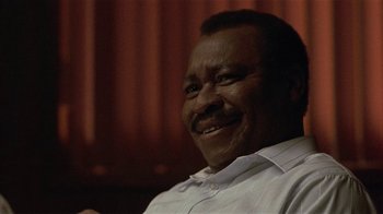 Movie still from “One False Move” (1991), directed by Carl Franklin – A person sitting in a chair; Close Up shot, Low angle