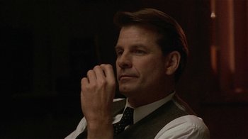 Movie still from “One False Move” (1991), directed by Carl Franklin – A person wearing a suit and tie; Close Up shot, Low angle