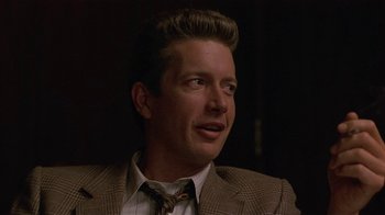 Movie still from “One False Move” (1991), directed by Carl Franklin – A person wearing a suit and tie; Close Up shot, Over the shoulder angle