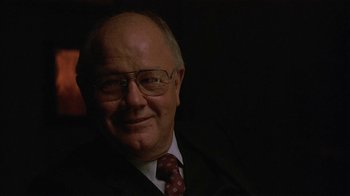 Movie still from “One False Move” (1991), directed by Carl Franklin – An older man wearing glasses and a suit and tie; Close Up shot, Over the shoulder angle
