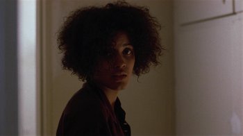 Movie still from “One False Move” (1991), directed by Carl Franklin – A woman with a very large curly hair style; Close Up shot, Over the shoulder angle