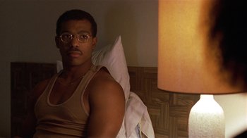 Movie still from “One False Move” (1991), directed by Carl Franklin – A man sitting on a bed in a room with a lamp; Close Up shot, Over the shoulder angle