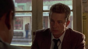 Movie still from “One False Move” (1991), directed by Carl Franklin – A person wearing a suit and tie; Close Up shot, Over the shoulder angle