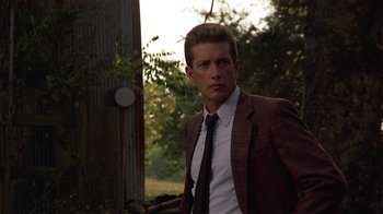 Movie still from “One False Move” (1991), directed by Carl Franklin – A man wearing a suit and tie standing next to a tree; Close Up shot, Low angle