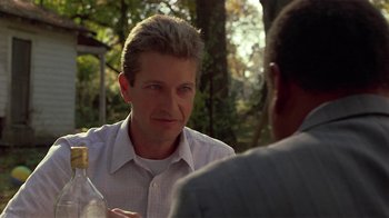 Movie still from “One False Move” (1991), directed by Carl Franklin – A man in a white dress shirt is talking to another man in a gray suit; Close Up shot, Over the shoulder angle