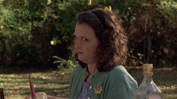 Movie still from “One False Move” (1991), directed by Carl Franklin – A young girl with a green sweater and a black headband; Close Up shot, Over the shoulder angle