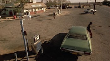 Movie still from “One False Move” (1991), directed by Carl Franklin – An old car parked in the middle of a street; Extreme Wide shot, High angle