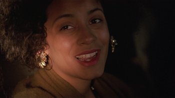 Movie still from “One False Move” (1991), directed by Carl Franklin – A person wearing a jacket and earrings; Close Up shot, Over the shoulder angle