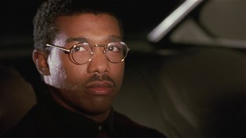 Movie still from “One False Move” (1991), directed by Carl Franklin – A person wearing glasses; Close Up shot, Low angle