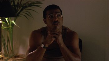 Movie still from “One False Move” (1991), directed by Carl Franklin – A man sitting in a chair with his hands clasped together; Close Up shot, Low angle