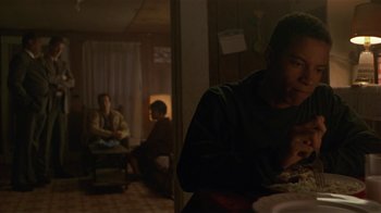 Movie still from “One False Move” (1991), directed by Carl Franklin – A man sitting at a table eating a meal; Medium shot, Over the shoulder angle
