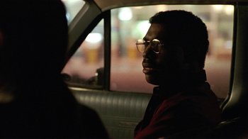Movie still from “One False Move” (1991), directed by Carl Franklin – A man sitting in the back seat of a car at night; Close Up shot, Over the shoulder angle