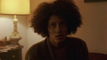 Movie still from “One False Move” (1991), directed by Carl Franklin – A woman with a very large afro is looking at the camera; Close Up shot, Over the shoulder angle