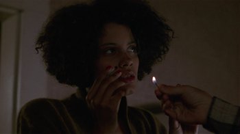 Movie still from “One False Move” (1991), directed by Carl Franklin – A woman lighting a cigarette in the dark; Close Up shot, Over the shoulder angle