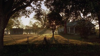 Movie still from “One False Move” (1991), directed by Carl Franklin – The sun is setting over a farm house and trees; Extreme Wide shot, Low angle