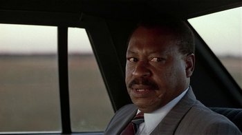 Movie still from “One False Move” (1991), directed by Carl Franklin – A man sitting in the back seat of a car; Close Up shot, Low angle