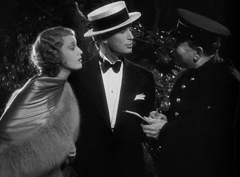 Movie still from “One Hour with You” (1932), directed by George Cukor – A man and a woman are talking to a man in a suit; Medium shot, Over the shoulder angle
