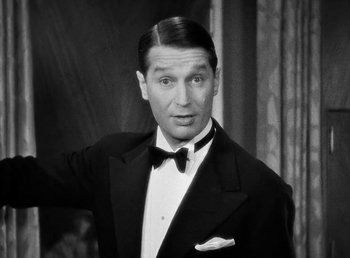 Movie still from “One Hour with You” (1932), directed by George Cukor – A man in a suit and bow tie; Close Up shot, Low angle