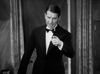 Movie still from “One Hour with You” (1932), directed by George Cukor – A black and white photo of a man in a tuxedo; Medium shot, Low angle