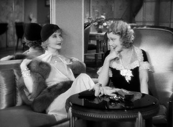 Movie still from “One Hour with You” (1932), directed by George Cukor – Two women sitting at a table talking to each other; Medium shot, High angle
