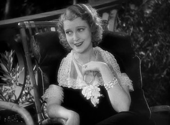 Movie still from “One Hour with You” (1932), directed by George Cukor – An old photo of a woman sitting in a chair; Close Up shot, High angle