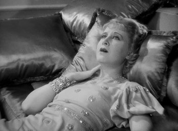 Movie still from “One Hour with You” (1932), directed by George Cukor – An old photo of a woman laying on a couch; Close Up shot, Overhead angle