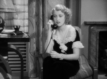 Movie still from “One Hour with You” (1932), directed by George Cukor – A woman sitting on a chair talking on a phone; Medium shot, High angle