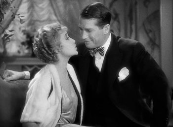Movie still from “One Hour with You” (1932), directed by George Cukor – A man and a woman standing next to each other; Medium shot, High angle