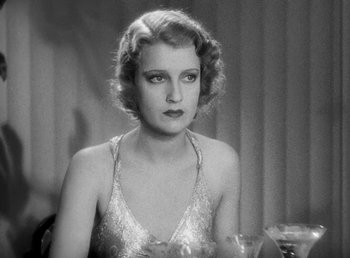 Movie still from “One Hour with You” (1932), directed by George Cukor – An old black and white photo of a woman in a silver dress; Close Up shot, High angle