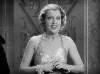 Movie still from “One Hour with You” (1932), directed by George Cukor – An old photo of a woman in a silver dress; Close Up shot, Low angle