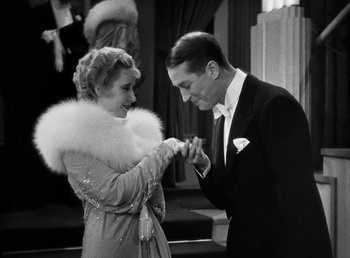 Movie still from “One Hour with You” (1932), directed by George Cukor – A man and a woman are holding hands and smiling; Medium shot, High angle