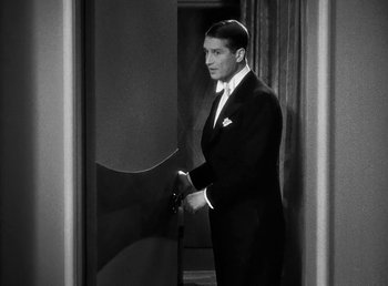 Movie still from “One Hour with You” (1932), directed by George Cukor – A black and white photo of a man in a suit; Medium shot, High angle