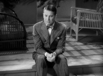 Movie still from “One Hour with You” (1932), directed by George Cukor – A black and white photo of a man sitting on steps; Medium shot, High angle