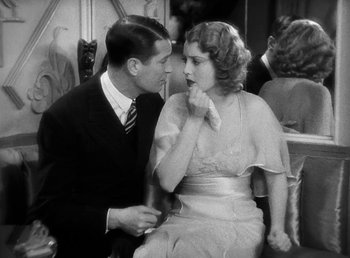 Movie still from “One Hour with You” (1932), directed by George Cukor – A man and a woman sitting next to each other; Medium shot, High angle
