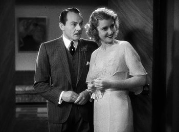 Movie still from “One Hour with You” (1932), directed by George Cukor – An older man standing next to an older woman; Medium shot, Low angle