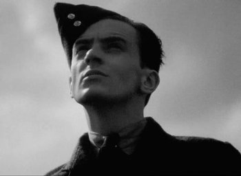 Movie still from “One of Our Aircraft Is Missing” (1942), directed by Emeric Pressburger – A man with a hat on his head looking up; Close Up shot, Low angle