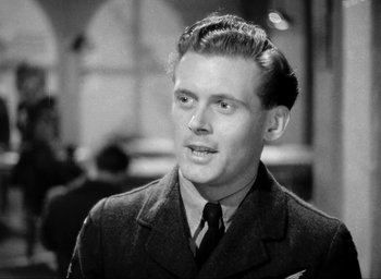 Movie still from “One of Our Aircraft Is Missing” (1942), directed by Emeric Pressburger – A man wearing a suit and tie in a black and white photo; Close Up shot, Low angle