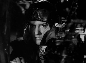 Movie still from “One of Our Aircraft Is Missing” (1942), directed by Emeric Pressburger – A black and white photo of a man wearing a helmet; Close Up shot, High angle