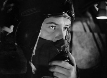 Movie still from “One of Our Aircraft Is Missing” (1942), directed by Emeric Pressburger – A black and white photo of a man wearing a helmet; Close Up shot, Low angle
