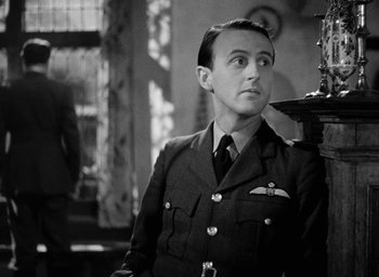 Movie still from “One of Our Aircraft Is Missing” (1942), directed by Emeric Pressburger – A man in a military uniform looking to his left; Close Up shot, Low angle