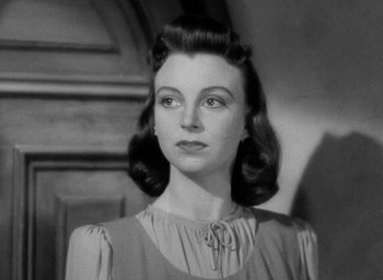 Movie still from “One of Our Aircraft Is Missing” (1942), directed by Emeric Pressburger – An old photo of a woman in a dress looking to her left; Close Up shot, Low angle