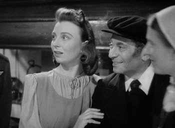 Movie still from “One of Our Aircraft Is Missing” (1942), directed by Emeric Pressburger – An old black and white photo of a man and a woman; Medium shot, Over the shoulder angle