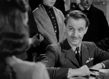 Movie still from “One of Our Aircraft Is Missing” (1942), directed by Emeric Pressburger – A black and white photo of a man sitting at a table; Close Up shot, Over the shoulder angle