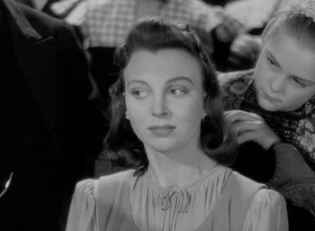 Movie still from “One of Our Aircraft Is Missing” (1942), directed by Emeric Pressburger – An old black and white photo of a woman; Close Up shot, Over the shoulder angle